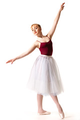 Young beautiful ballerina in white tutu and pointe shoes doing dancing pose © YouraPechkin