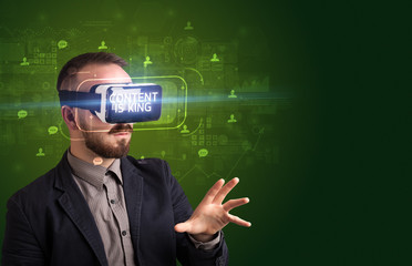 Businessman looking through Virtual Reality glasses with CONTENT IS KING inscription, social networking concept