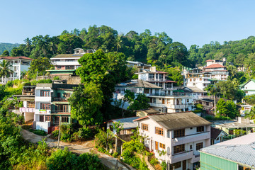 Fototapeta premium Beautiful builings on the green hills in the downtown, nex to the Kandy Lake or Kiri Muhuda or the Sea of Milk, an artificial lake in the heart of the hill city of Kandy, Sri Lanka