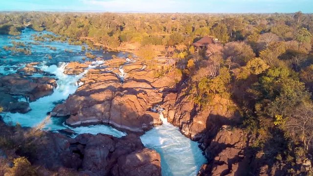 Khone Falls, series of cascading waterfalls and rapids over the Mekong river on Laos and Cambodia border panoramic aerial sunset view. Don Khon island, Four thousand islands area.
