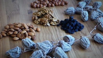 dried fruit mix of dried persimmon, raisins and different varieties of nuts on a wooden table