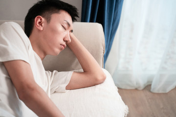 asian young man sleep on sofa