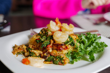 View of Thai style of Stir fry Spicy basil with rice noodle, vermicelli, and shrimp, on white dish.  