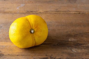 Ugly double organic lemon unusual shape on wooden textured surface with knife. Buying imperfect product to reduce food waste. Horizontal. Yellow bright color fruit. Cooking. Eco trend