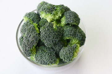 Fresh broccoli in the bowl on white background. top view.