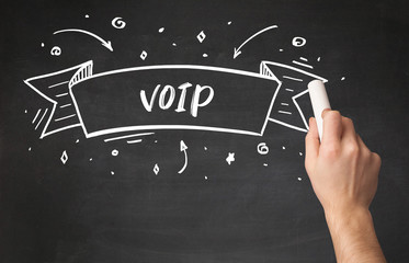 Hand drawing VOIP abbreviation with white chalk on blackboard