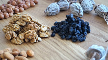 dried fruit mix of dried persimmon, raisins and different varieties of nuts on a wooden table