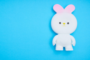 White easter bunny toy on trend blue background Copy space Top view