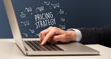 Businessman working on laptop with PRICING STRATEGY inscription, online shopping concept