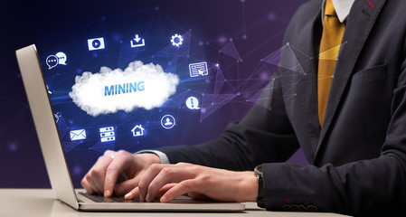 Businessman working on laptop with MINING inscription, modern technology concept