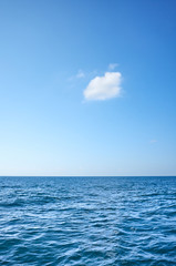 Fototapeta na wymiar Single cloud over the ocean on a sunny day.