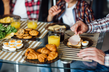 Close up photo, early morning family breakfast, hands with plates of food.
