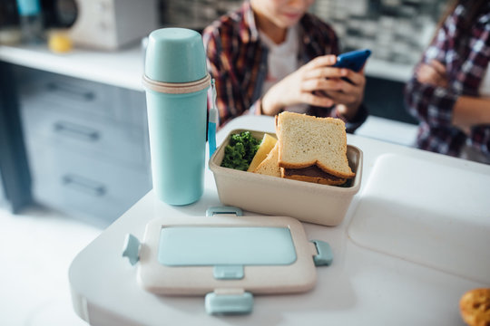 Cropped image, lunch box on table with thermos ready for school.