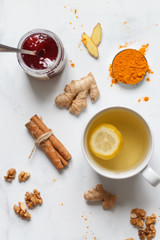 on a light background, tea with lemon, ginger, turmeric, jam. Set for health