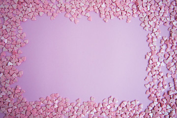 Rectangular frame with small mother-of-pearl hearts on a pink background, Valentine's day concept. Postcard.