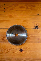 Circular saw blade for wood work isolated on a wooden background.