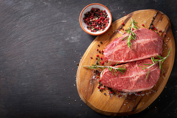 fresh meat with rosemary and spices on a wooden board