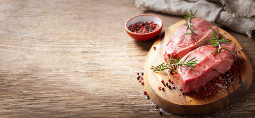 fresh meat with rosemary and spices on a wooden board