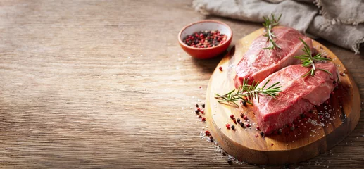 Fotobehang fresh meat with rosemary and spices on a wooden board © Nitr