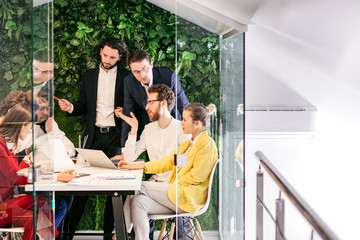 brainstorm of young successful business people gathered to discuss new business strategies, ideas together in modern office, successful interaction