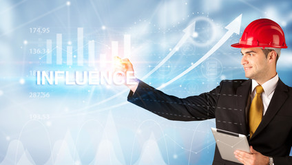 Young businessman with helmet drawing INFLUENCE inscription, modern business technology concept