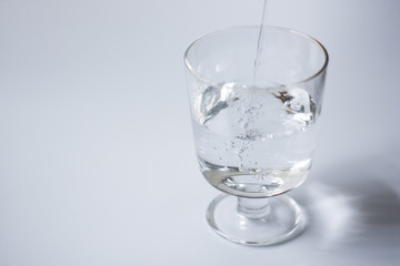 ワイングラスに注がれた水（白背景）