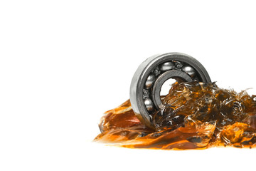 Closed up macro, ball bearing put into yellow transparent lithium grease isolated on white...