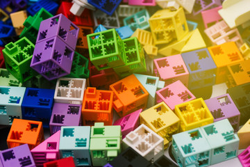 Details of the plastic constructor. Scattered colored blocks of the designer on the table. Education and science concept