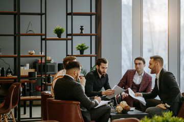 business coworking of young caucasian bearded men in office gathered to discuss business ideas, share experiences and opinions, successful cooperation of enthusiastic business people