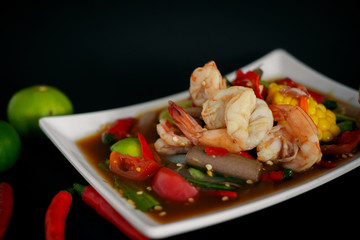 Spicy papaya salad with shrimp, and hot chilli, Thai food in white dish on black background
