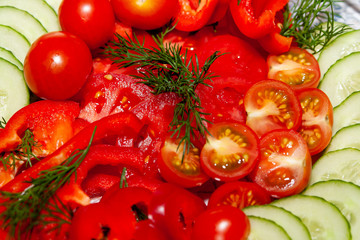 Sliced ​​fresh tomatoes and cucumbers, with a sprig of dill. Snack on the festive table.