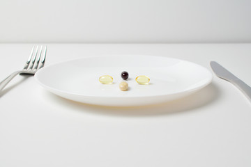 Meal replacement.  Multivitamin and mineral supplements. Table set with tablets. Fish oil, vitamins and astaxantnin, omega.