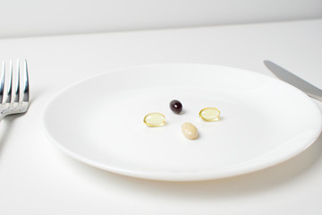 Fish oil, vitamins and astaxantnin. Multivitamin and mineral supplements. Table set with tablets. Meal replacement.