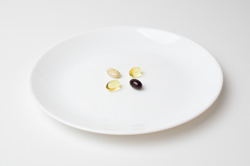 Multivitamin and mineral diet supplements. Plate with tablets. Meal replacement. Closeup.