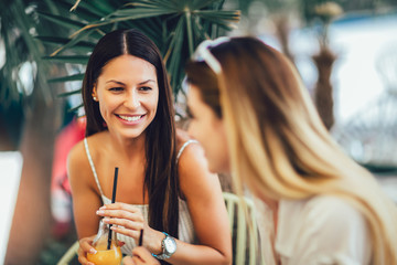 Beautiful girls drinking cocktail in cafe and having fun.