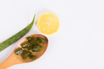 Aloe vera fresh leaves with slices and gel on wooden spoon. isolated over white. Aloe vera is a popular medicinal herb used for health and beauty.