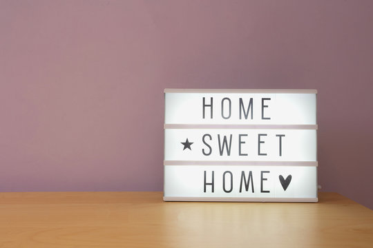 'Home sweet home' text in lighbox on wooden shelf, modern retro decoration