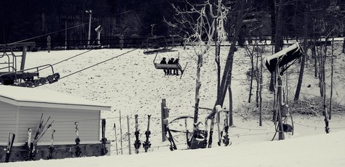 Black and white view of people on ski lift