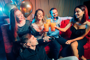 young incendiary caucasian people gathered in karaoke bar to sing and have fun, celebrating, emotional group of young guys and ladies