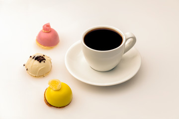 Cup of strong aromatic coffee espresso with various candies on the white background