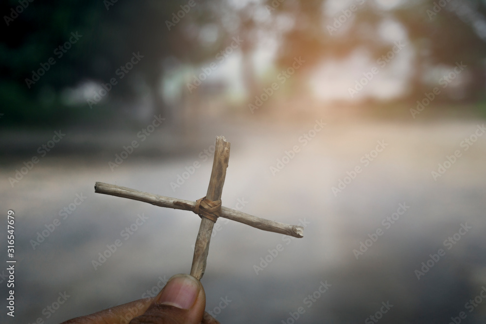 Wall mural hand holding a cross. jesus christ. symbol of the belief christ religion at tomb