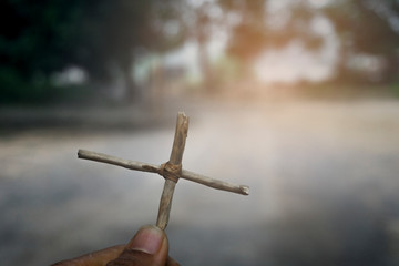 Hand holding a cross. Jesus Christ. Symbol of The belief christ religion at tomb