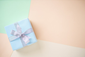 Holiday design template with festive gift box wrapped with ribbons. Multicolored background, copy space. Birthday, Valentines, mother's day, celebration concept