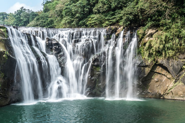 Obraz premium Wodospad Shihfen, wysoki na piętnaście metrów i szeroki na 30 metrów, jest największym wodospadem typu kurtynowego na Tajwanie