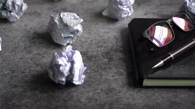 Crumpled paper balls with notebook on grunge background, Creativity problems concept