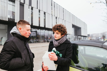 Two student youth men in black coats meets