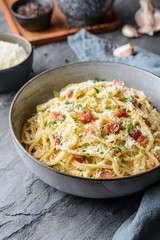 Classic pasta Carbonara, hearty Italian dish made with Spaghetti, egg, fried bacon, topped with grated Parmesan cheese and black pepper