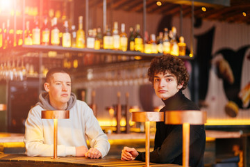 Two young guys friends with beards arguing in a coffee shop
