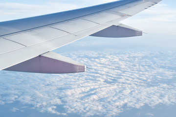 plane wing and cloud floating on sky through window frame