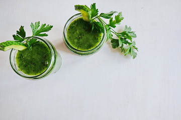 Green cocktail of spinach, lemon, cucumber and parsley on a light background. The concept of healthy nutrition, detox, green, diet, vegan, keto, fit. Copy space. Top view